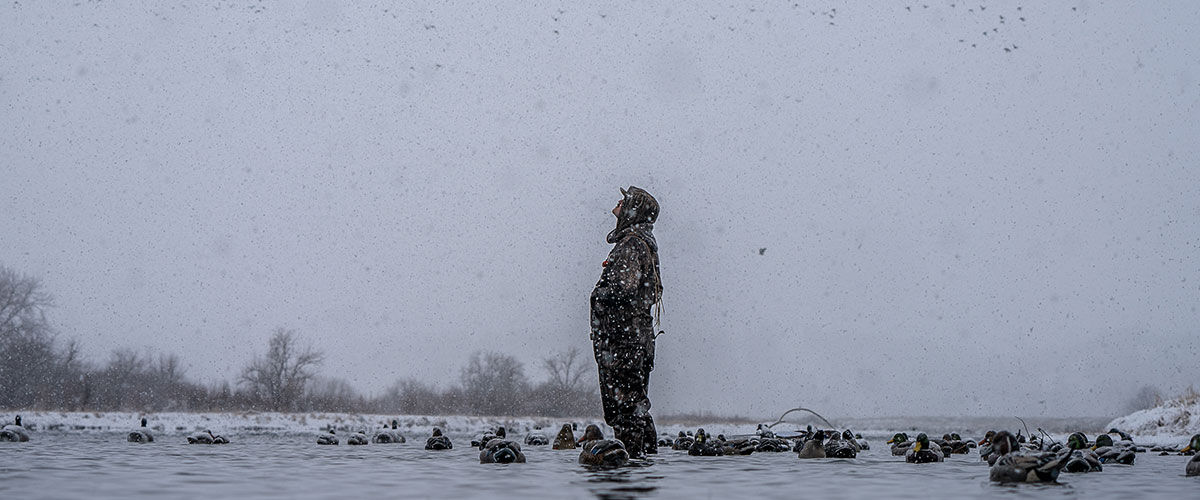 hunter standing in the water with decoys